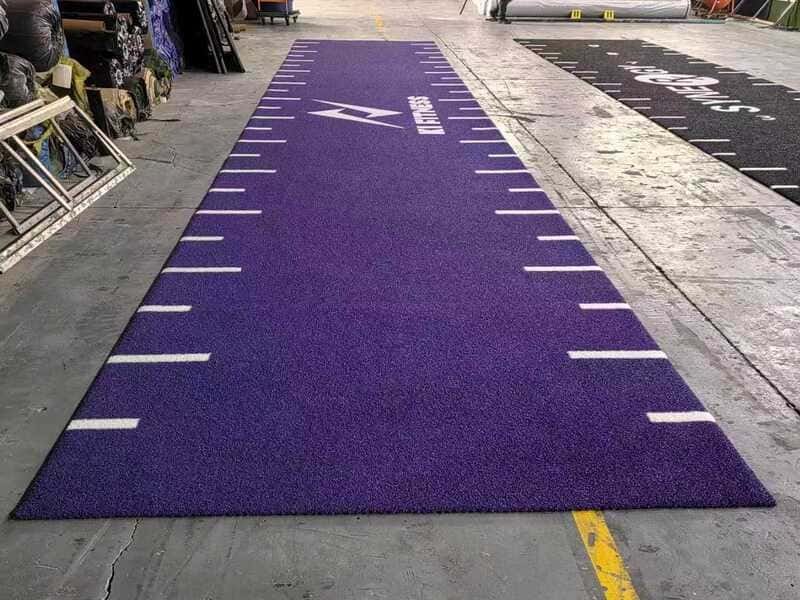 Un ouvrier brosse le gazon d'un gymnase pour en raviver les fibres